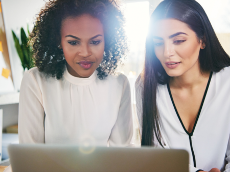 Two leaders looking at a laptop to find resources related to people-centered desgn